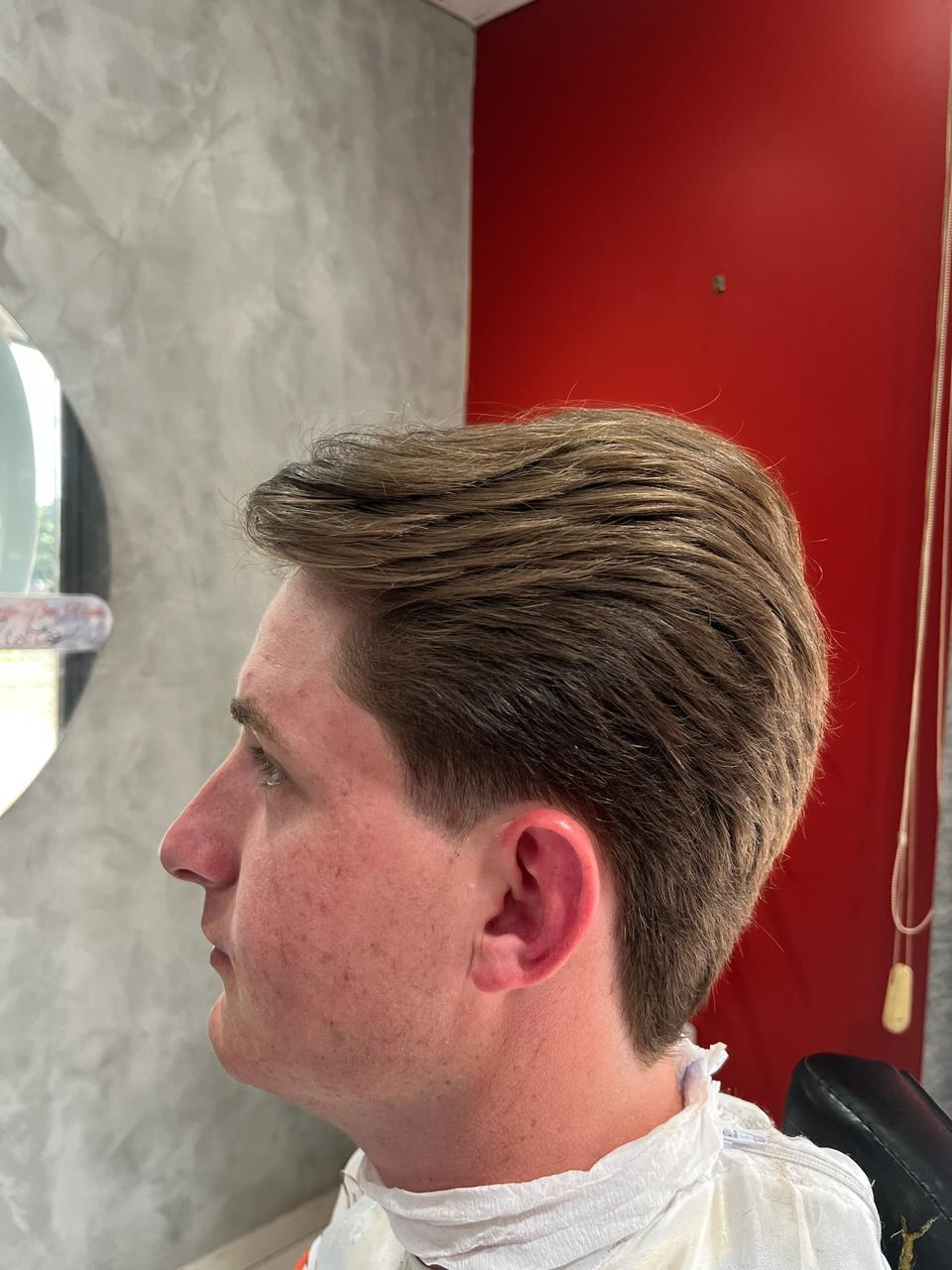 Cabelo penteado para trás com degradê nas laterais